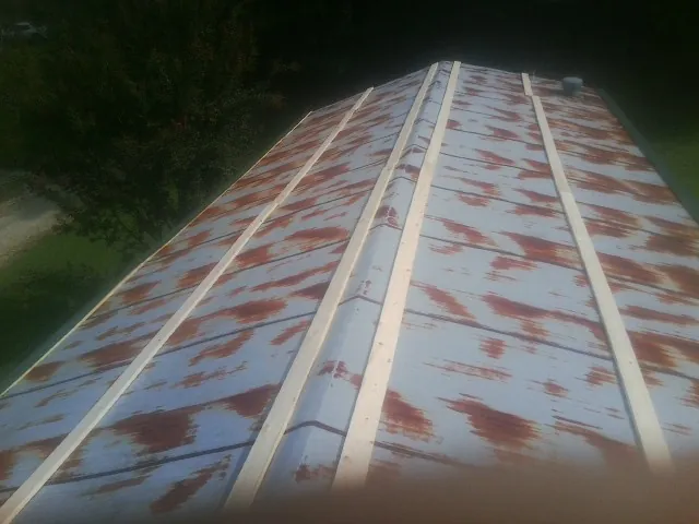 Rusted metal roof panels with new wood purlins before replacement — Storm Damage Roof Repair in Saint Joe by Roofing Brothers