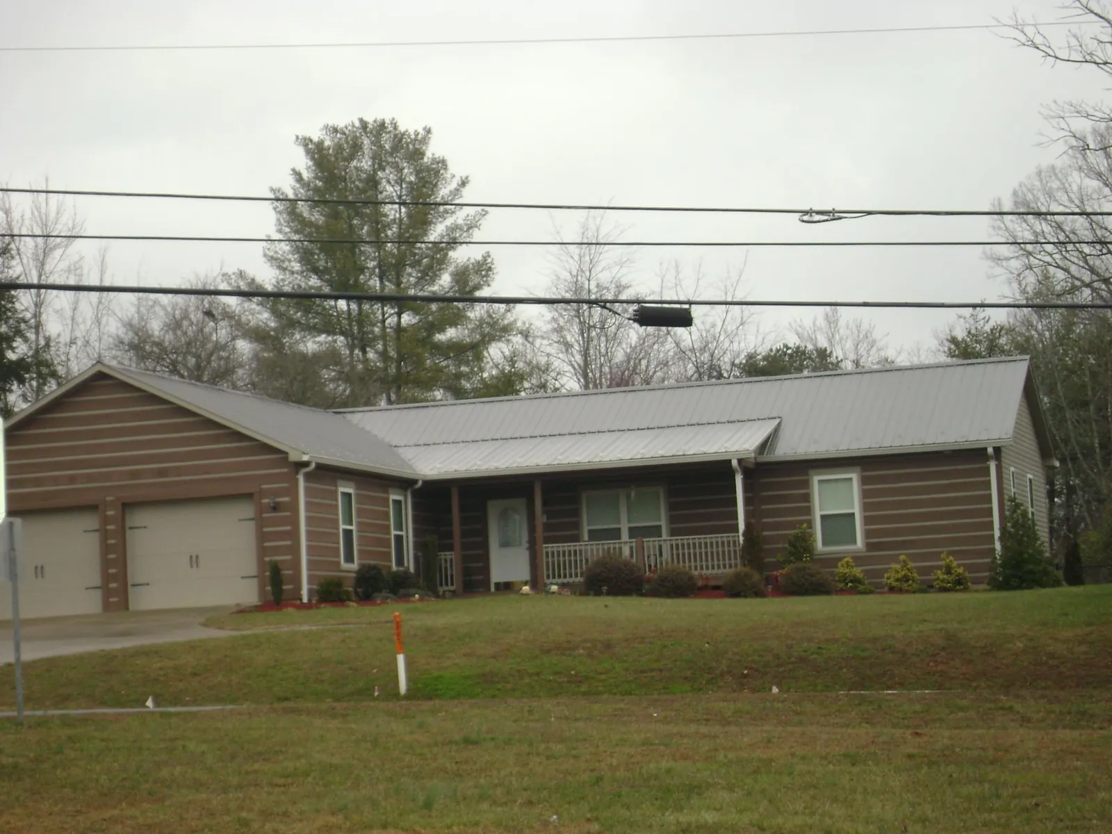 Gray metal roof on a log sided ranch home with a front porch in Saint Joe